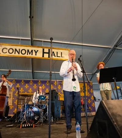 Jazz band performing live on stage under Economy Hall sign in a music festival tent setting.