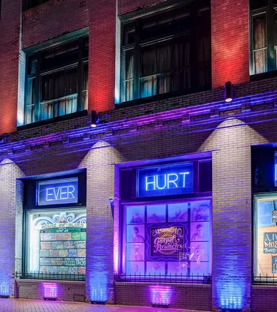 House of Blues building lit with purple and blue lights with overlaid text reading HELP EVER HURT NEVER
