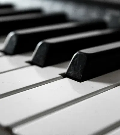 Close-up view of black and white piano keys arranged in repeating pattern on keyboard.