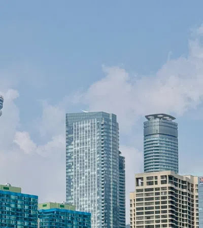 Toronto skyline with CN Tower and modern skyscrapers under a partly cloudy sky on a clear day
