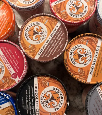 Top view of assorted New Orleans Ice Cream Company pints with various colorful flavors labeled on lids.