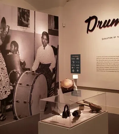 Exhibit showcasing the evolution of New Orleans beat with vintage jazz band photo and percussion instruments.
