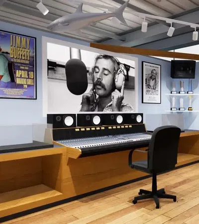 Modern music studio with mixing console, black office chair, framed posters, and a large black-and-white musician portrait.