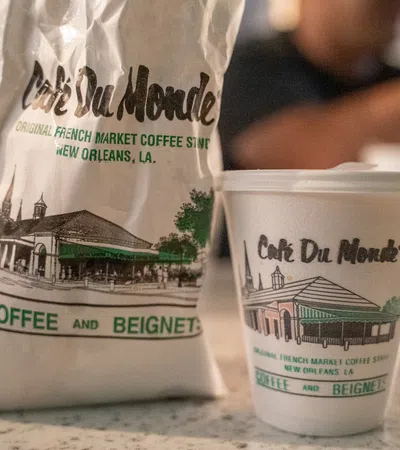 Cafe Du Monde coffee cup and bag featuring French Market coffee shop branding from New Orleans, Louisiana.