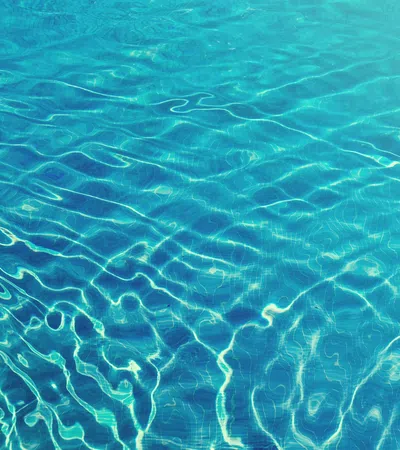 Clear blue water surface with ripples reflecting sunlight creating dynamic patterns