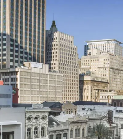 Downtown cityscape featuring a mix of historic and modern buildings under clear blue sky.