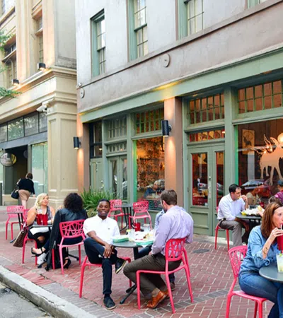Outdoor dining at Juan's Flying Burrito with patrons enjoying food and drinks at red tables on a city sidewalk.