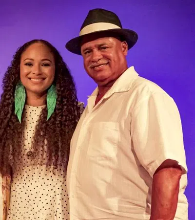 Smiling three generations family portrait with purple background and casual summer clothing