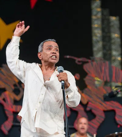 John Boutté holding a microphone and standing on a stage