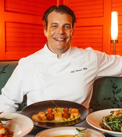 a person sitting on a couch with plates of food