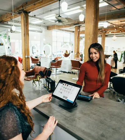 a person showing a person something on the tablet