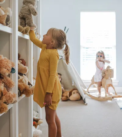 a person in a yellow dress in a room with teddy bears