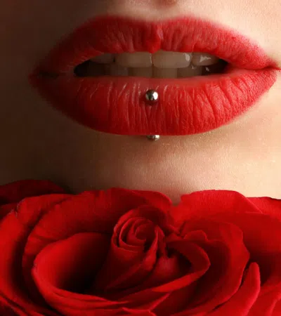a woman's lips with a red rose in front of her