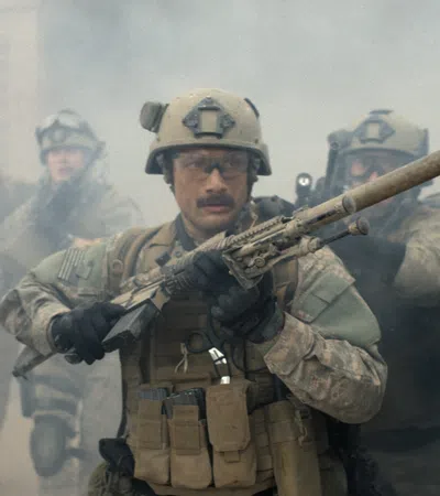 Soldiers in tactical gear advancing through smoke with weapons drawn in a dramatic military scene.