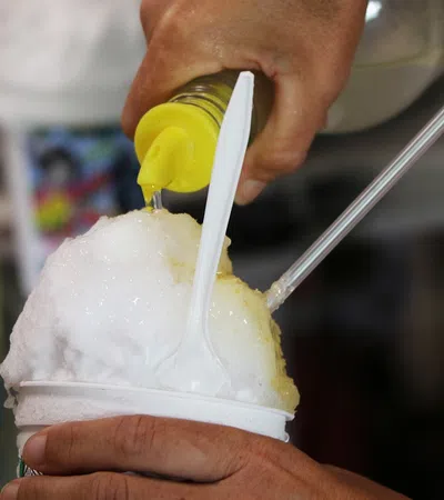 a person pouring a drink into a cup