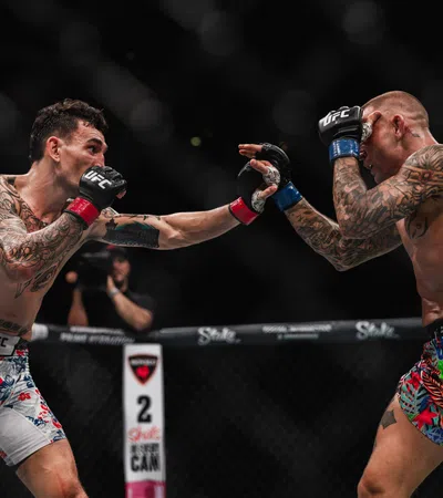Two tattooed UFC fighters exchange punches inside the Octagon during a mixed martial arts match.
