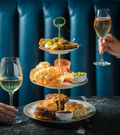 a couple of people holding wine glasses and a plate of food
