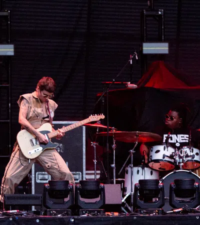 a man playing a guitar on a stage with a man playing drums