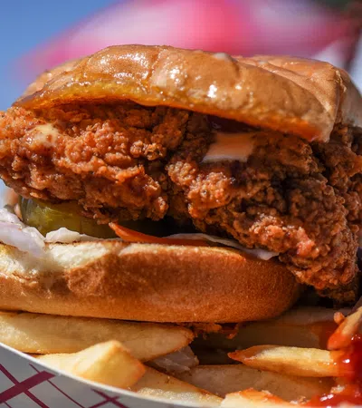 a person holding a burger