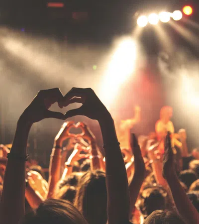 a crowd of people holding their hands up in the air