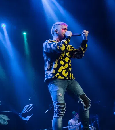 a man singing into a microphone on stage