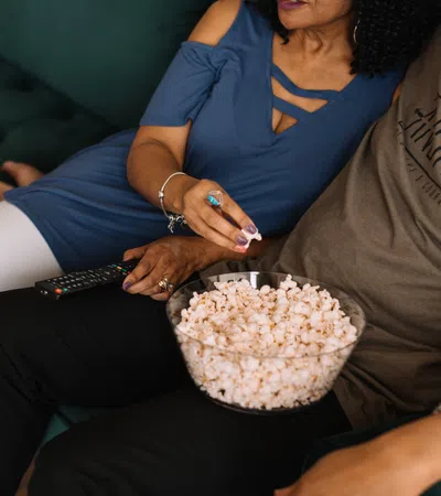 a woman and a man sitting on a couch with a cake