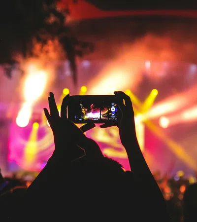 a person holding a camera in front of a crowd