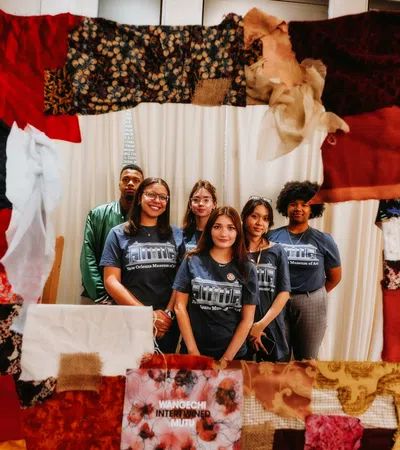 a group of people posing for a photo in front of a bed