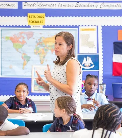 a person standing in front of a group of children sitting in a classroom