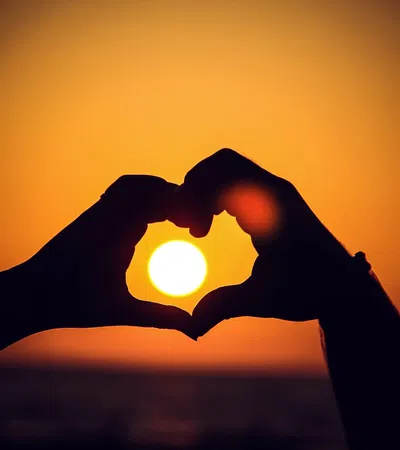 a person holding their hand up to the sun