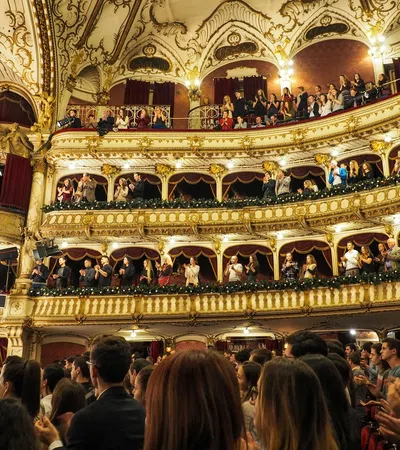 a group of people in a room with a stage and a large crowd