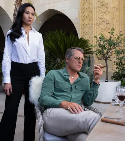 a woman standing next to a man sitting at a table