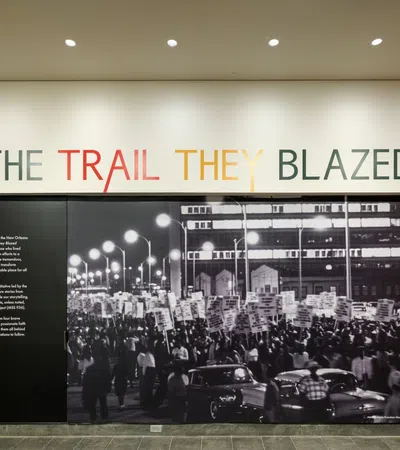 Black and white photo of a civil rights march under The Trail They Blazed exhibition title on a museum wall.