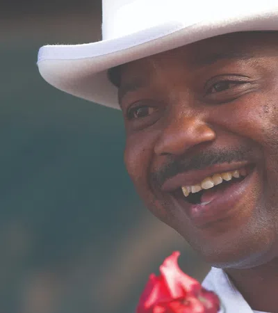 a man wearing a white hat and smiling at the camera