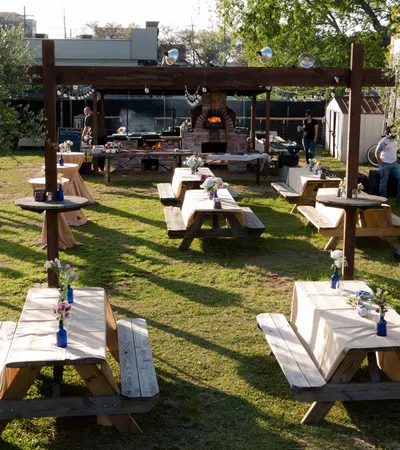 a group of people sitting at tables in a grassy area
