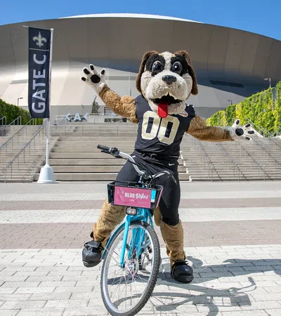 a person in a bear garment riding a bicycle