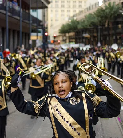a person holding a brass instrument in front of a crowd of people