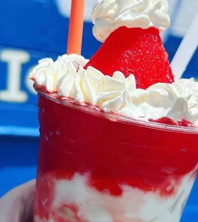 a hand holding a red drink with a straw