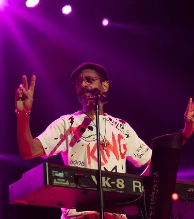 a person on a stage with the hands up and a microphone