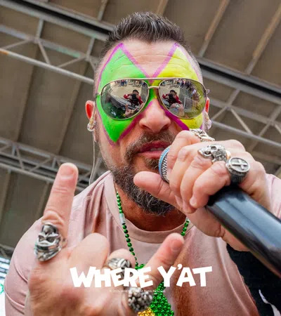 a person with colorful hair and sunglasses holding a microphone