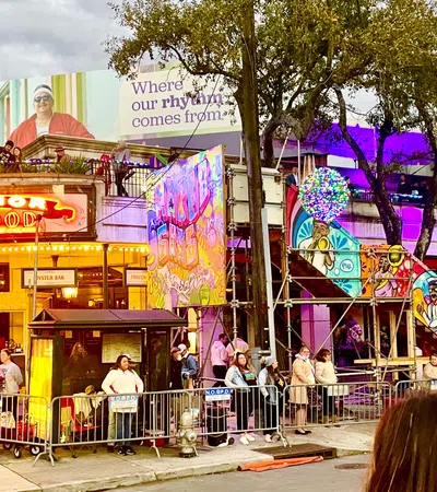 Crowd gathered outside a seafood restaurant decorated with colorful murals and festive lights at dusk.