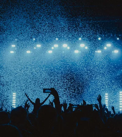 a crowd of people in front of a stage with lights