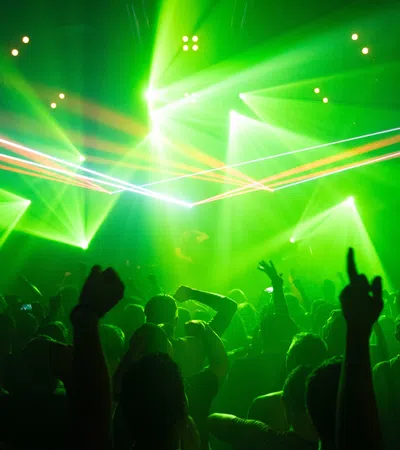 a crowd of people in front of a stage with green lights