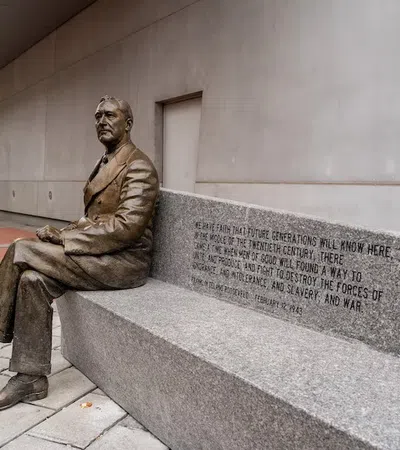 a statue of a man sitting on a stone bench