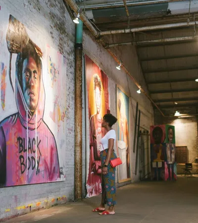 a person standing next to a wall with art on it