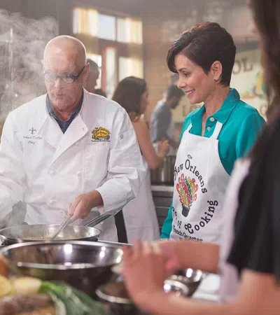 a man and a woman standing next to a table with food