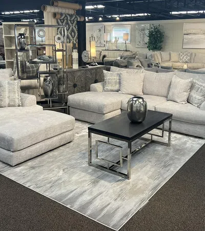 Modern living room setup featuring a stylish gray sectional sofa and contemporary coffee table on a plush area rug.