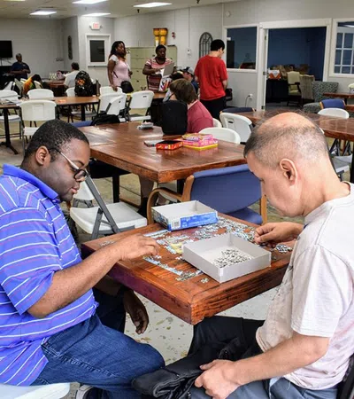 a couple of men sitting at a table playing a board game