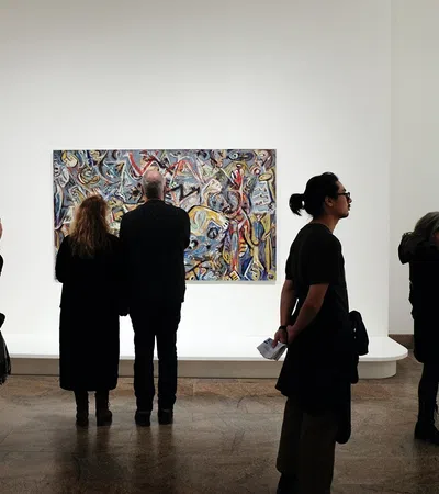 a group of people looking at a painting on a wall