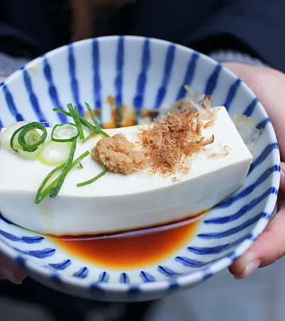 a person holding a bowl of food